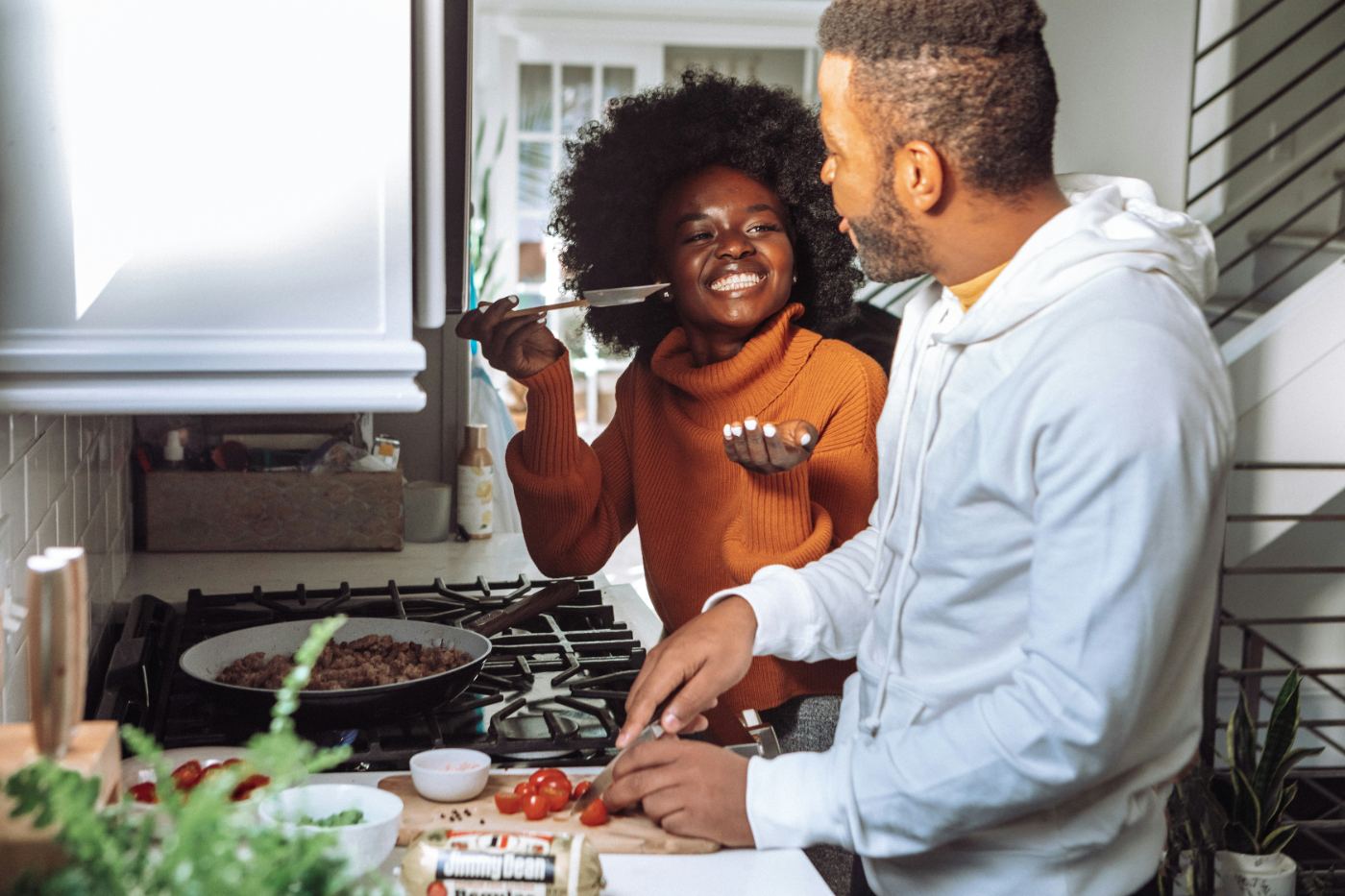 A couple cooking together at home, smiling